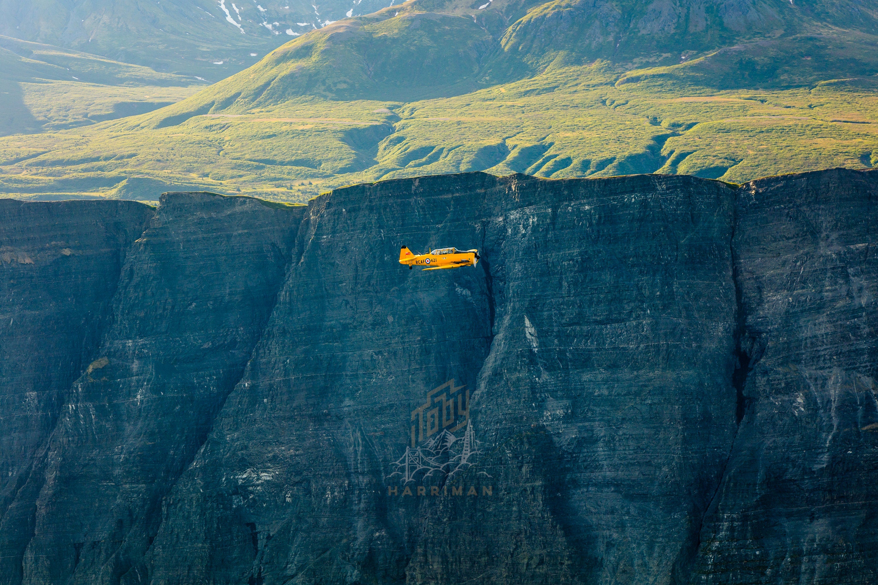 Commemorative Air Force Harvard Mk IV Flying by Alaskan Cliffs - Aerial Fine Art (Metal & Bamboo Prints)