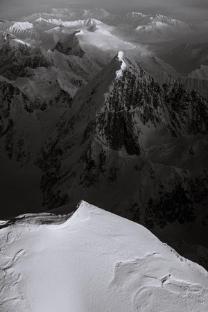 a black and white photo of a snow covered mountain