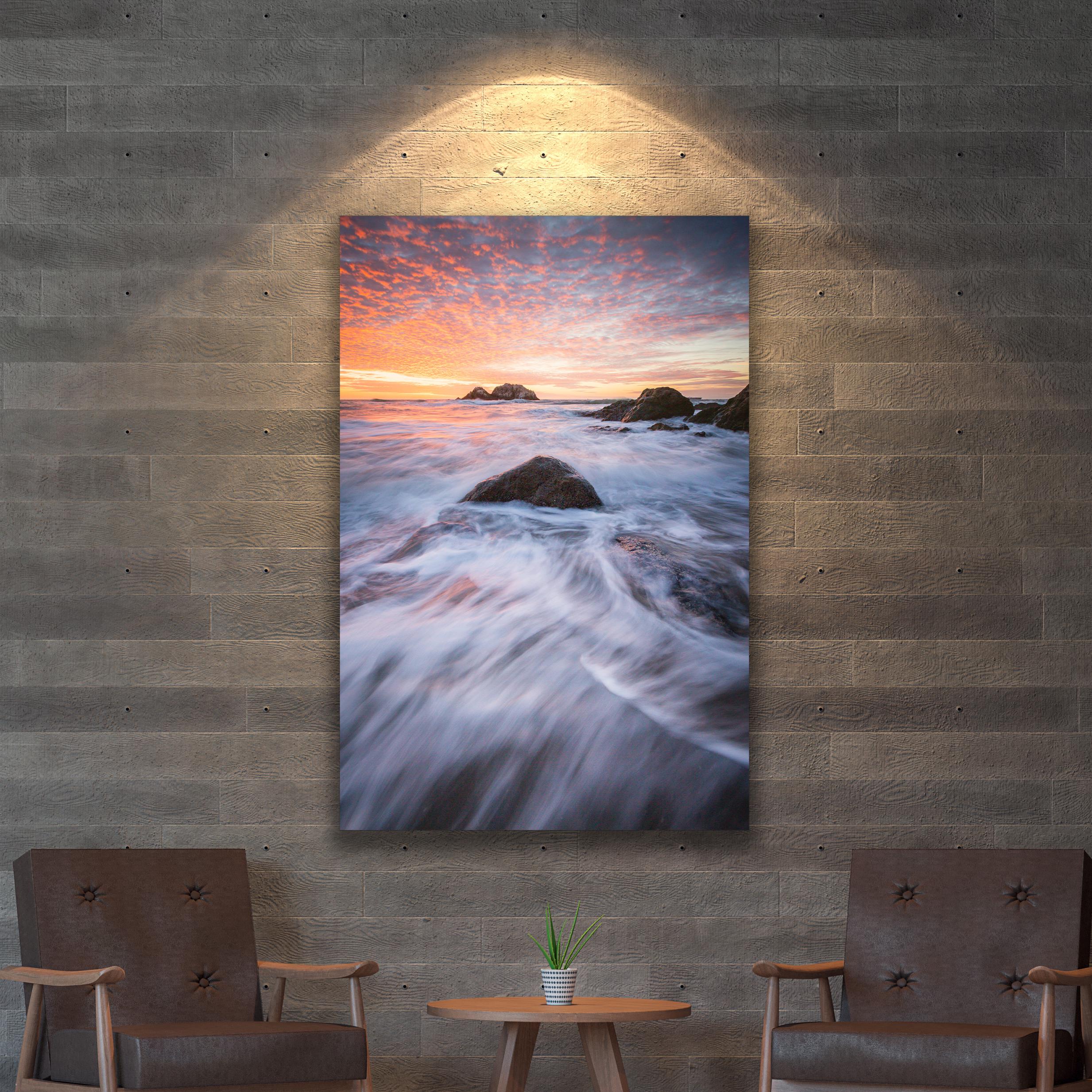 a room with a painting of a sunset on the wall