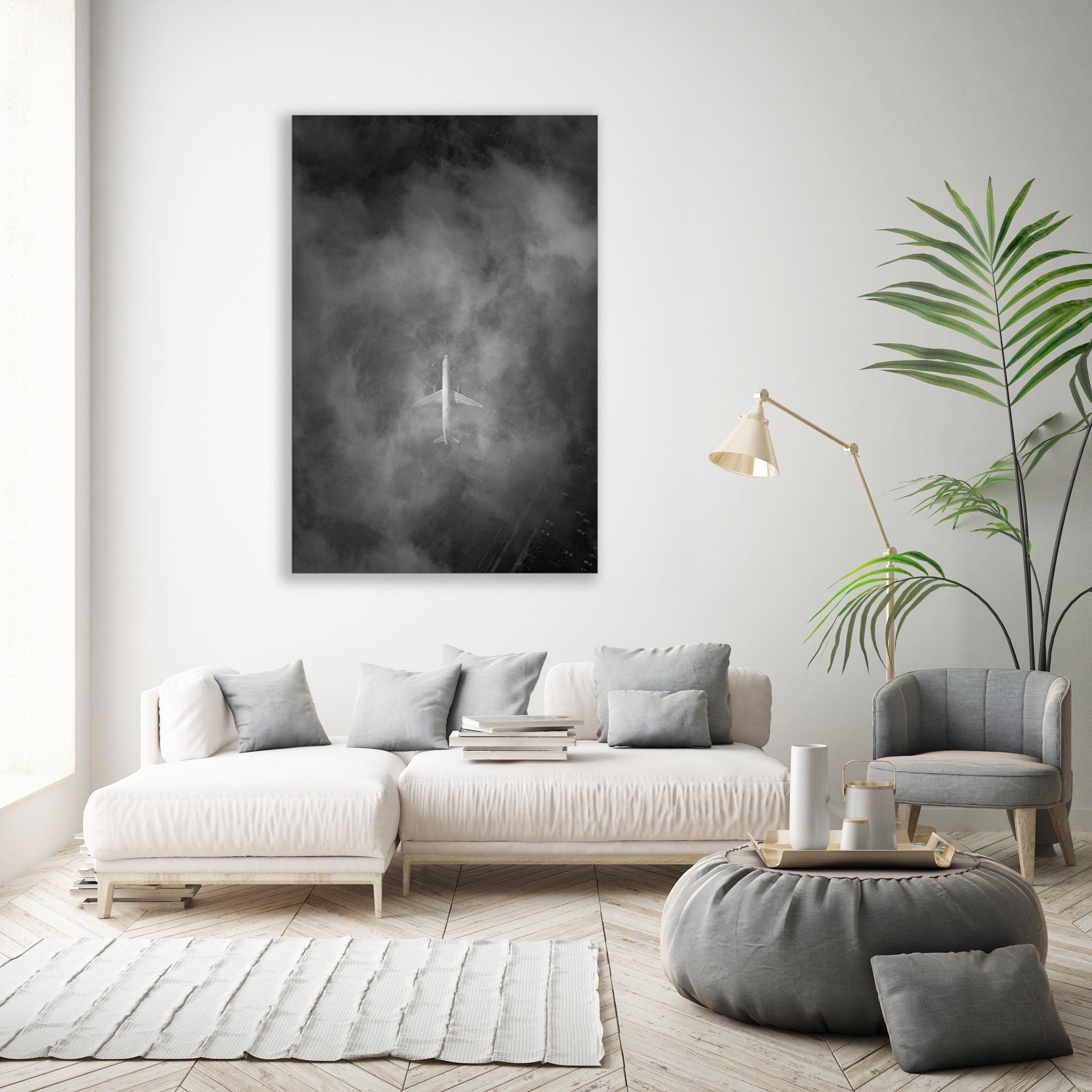 a living room with a white couch and a black and white painting