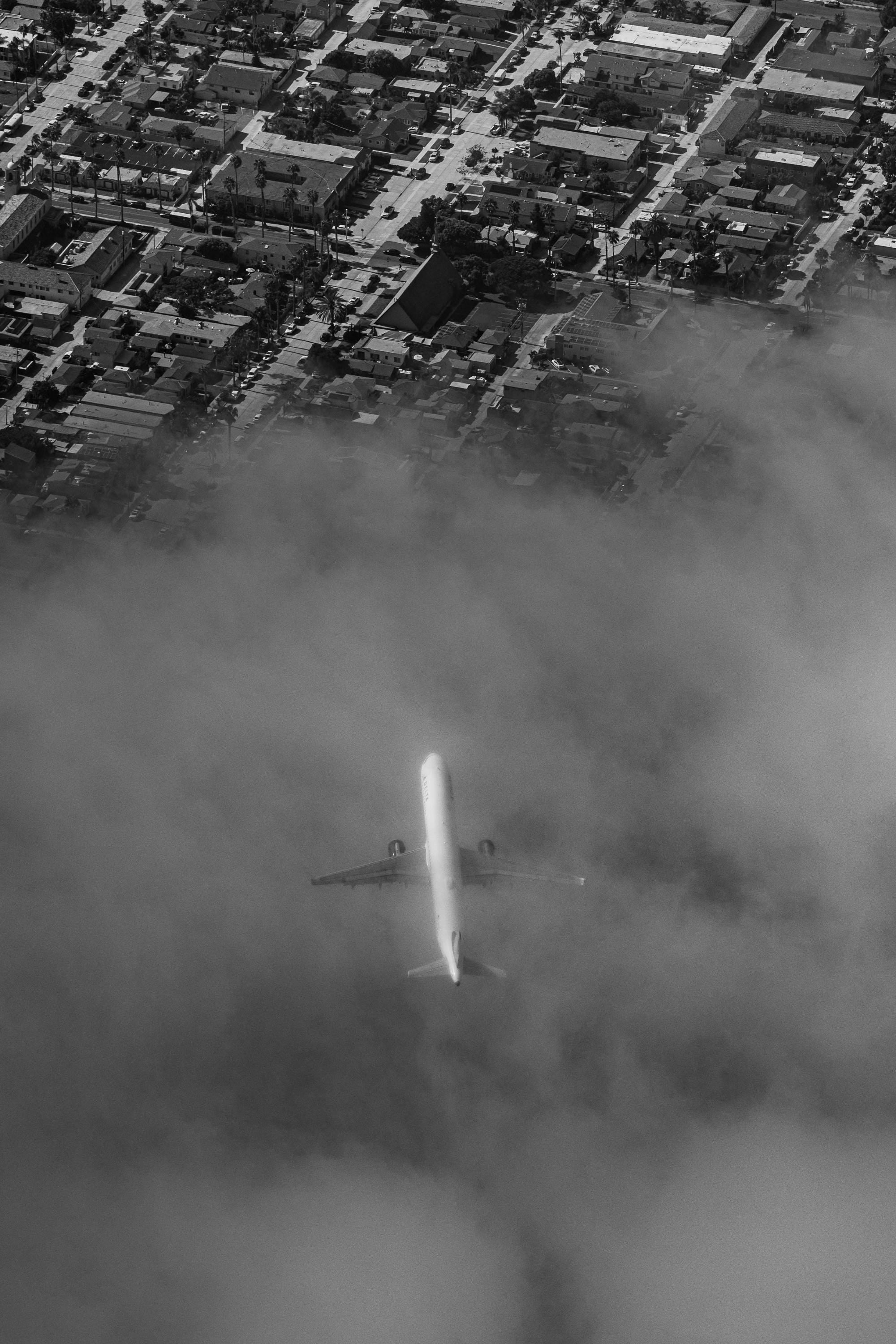 an airplane is flying through the clouds over a city