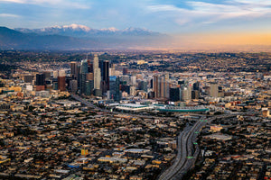 an aerial view of a city with mountains in the background