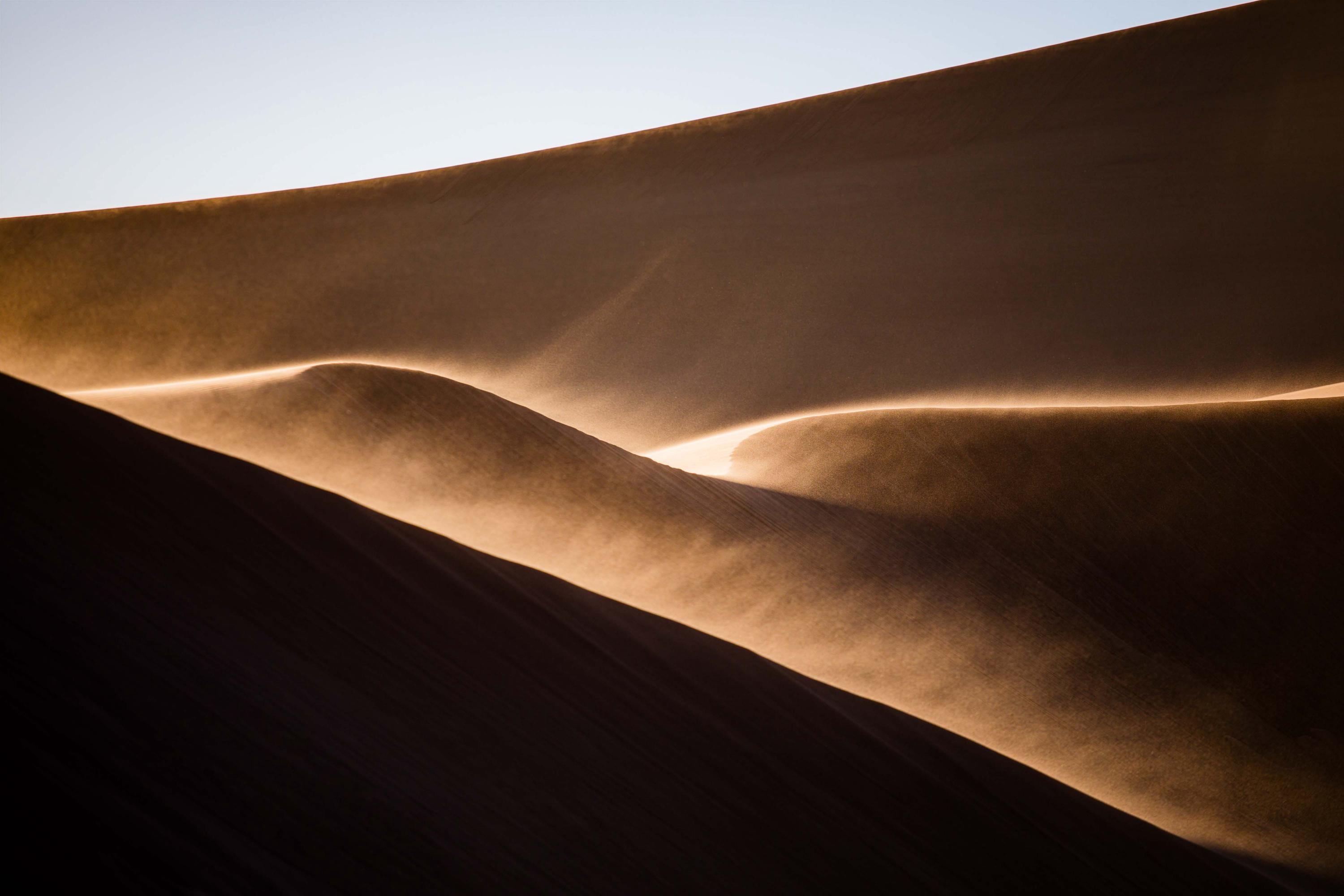 a desert landscape with sand blowing in the wind