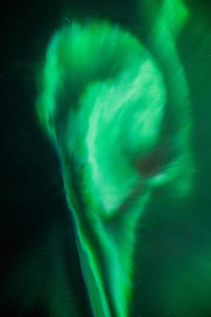 a green swirl in the sky with stars in the background